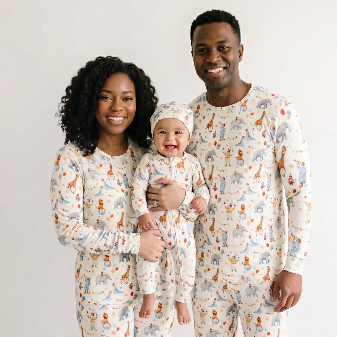 Family of three wearing matching pajamas with animal patterns on a plain background