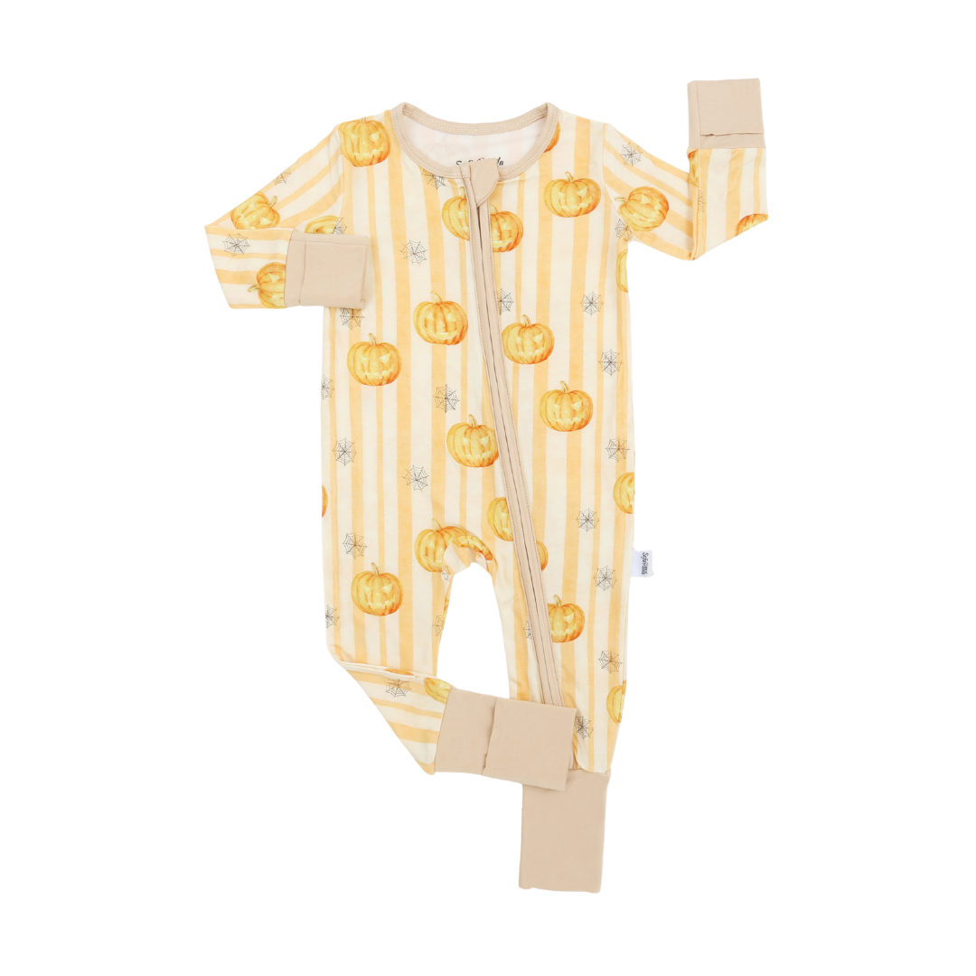 A baby long-sleeve footed sleeper with a front zipper, featuring a yellow and white vertical stripe pattern decorated with orange pumpkins and small gray stars, finished with solid beige cuffs and leg closures.